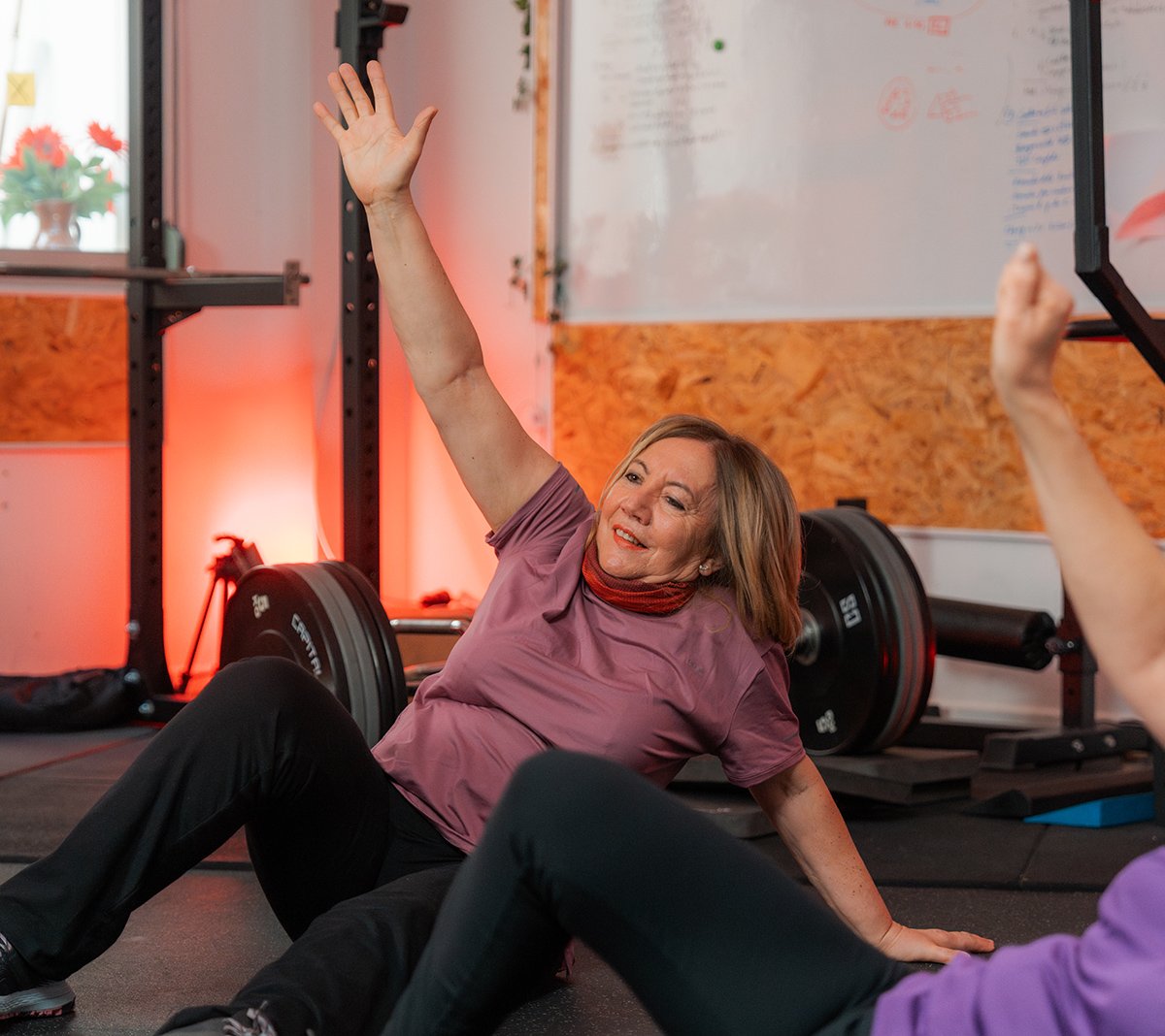 menopausia deporte Mujer senior en el gimnasio realizando ejercicios de movilidad articular.